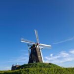 Mit dem Camper in den Niederlande, Windmühlen in der Natur nahe Rijkel unter blauem Himmel
