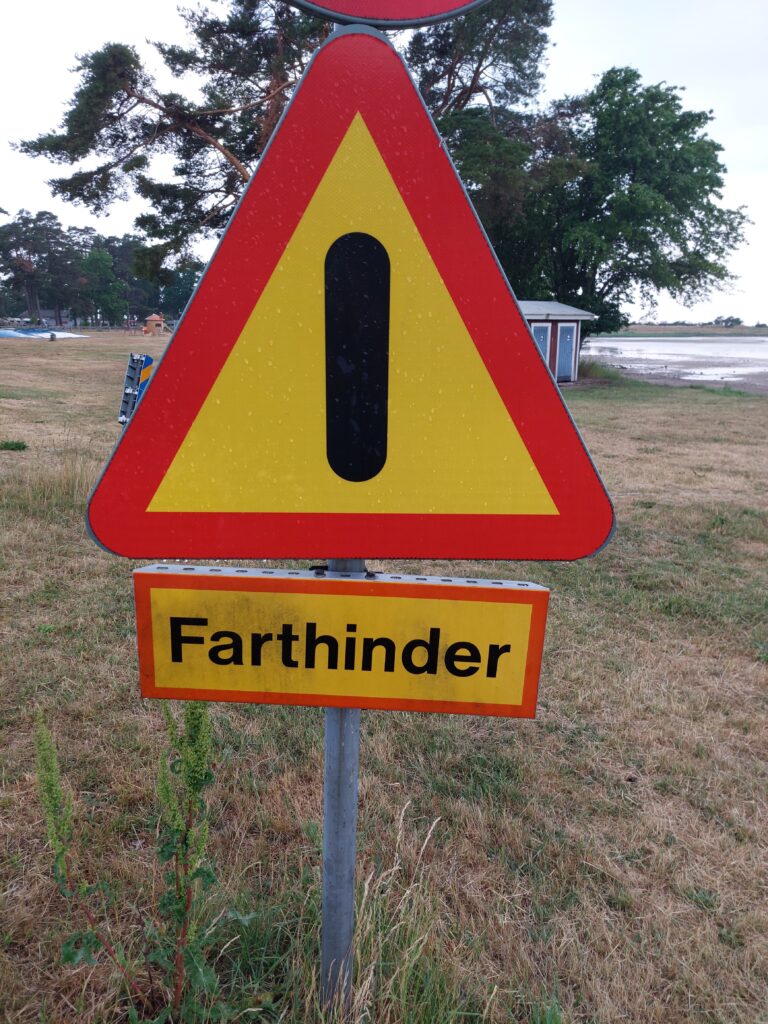 Schwedisches Verkehrsschild "Farthinder" am Straßenrand während unsere Camper Reise durch Schweden zwischen Natur und kleinen Landstraßen.