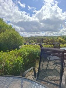 Aussicht von der Terrasse eines gemütlichen Cafés Drömmen in Schweden mit Blick ins Grüne und dramatischem Himmel nahe dem Wasserfall Forsakar