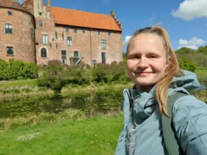 Jacki vor einem Schloss in Schweden während einer Wanderung durch den Park bei sonnigen Wetter.