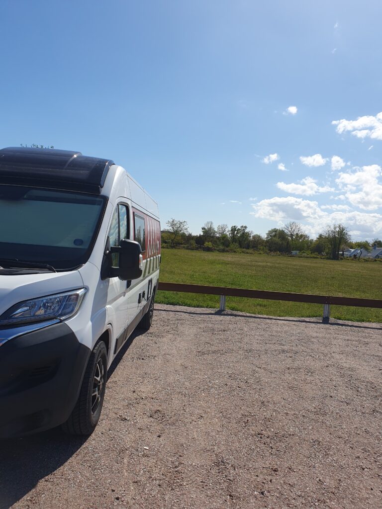 Camper hektor auf einem Parkplatz in Schweden unterwegs mit dem Wohnmobil und wichtige Regel zum übernachten. Der Platz ist an einem Parkplatz eines naturresevarrts. Es scheint die sonne.