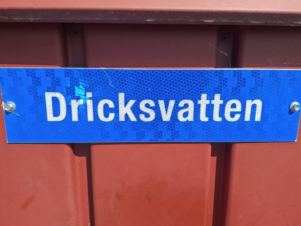 Kostenlose Trinkwasser Station in Schweden während unserer Reise in Schweden. Schild mit Aufschrift Dricksvatten