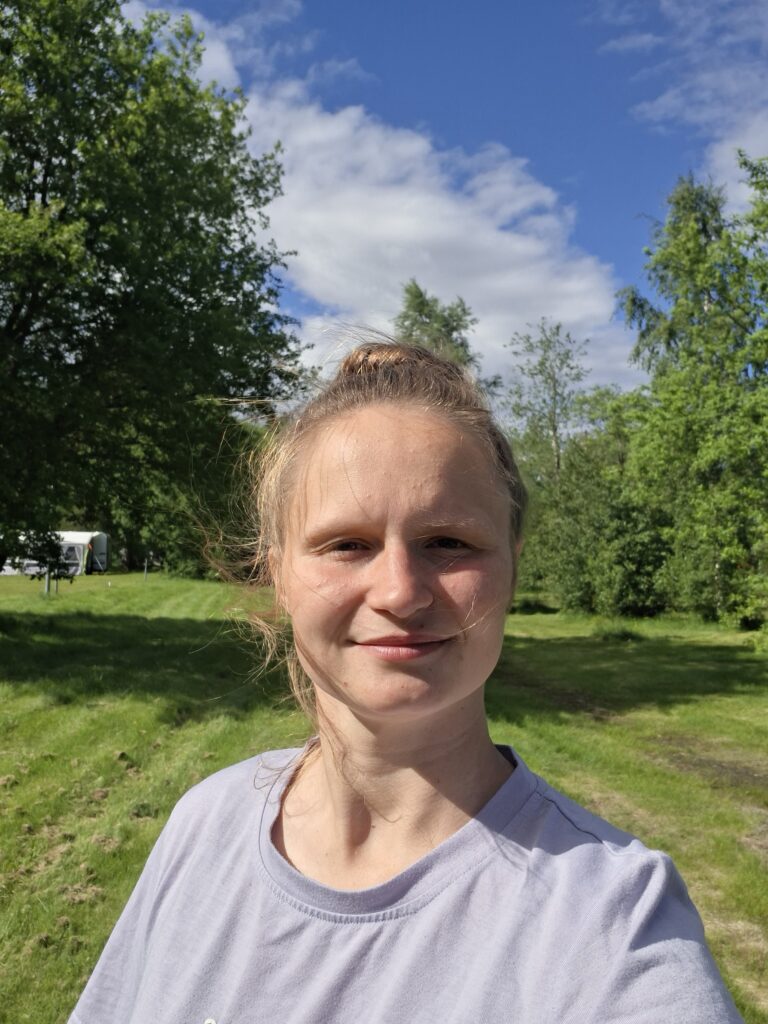 Jacqueline- Reisebloggerin für Vanlife mit Hund und Reisen im Camper. Jacqueline und im Hintergrund ist ein gepflegter Rasen.