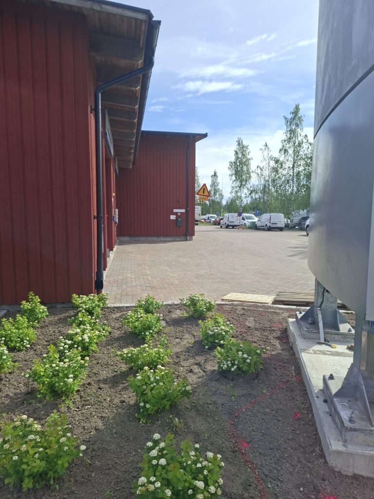 Rotes Gebäude mit Parkplatz und einfacher Umgebung in Schweden. Das Bild zeigt, dass günstige Häuser in Schweden oft in ländlichen Regionen liegen und der Kaufpreis nicht automatisch ein Schnäppchen bedeutet.