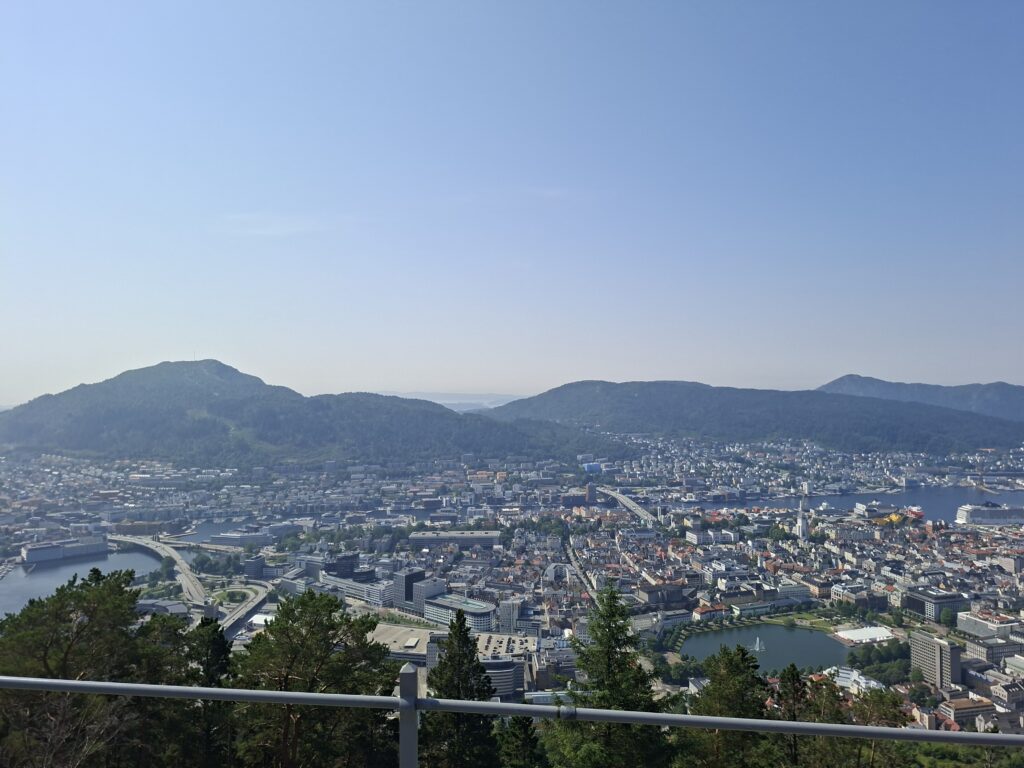 Panoramablick über die Stadt Bergen mit Hafen, Bergen, Brücken und umliegenden Bergen. Das Foto entstand während unserer Wanderung auf den Hausberg und zeigt die zweitgrößte Stadt Norwegens aus der Vogelperspektive.