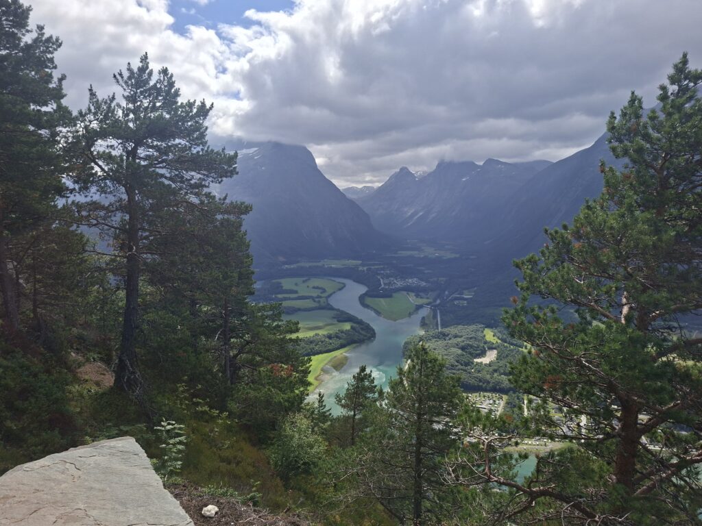 Panoramablick über ein norwegisches Tal mit Fluss, Bergen und dichter Natur. Die beeindruckende Landschaft zeigt die abwechslungsreiche Natur, die unsere Reise durch Norwegen so besonders gemacht hat.