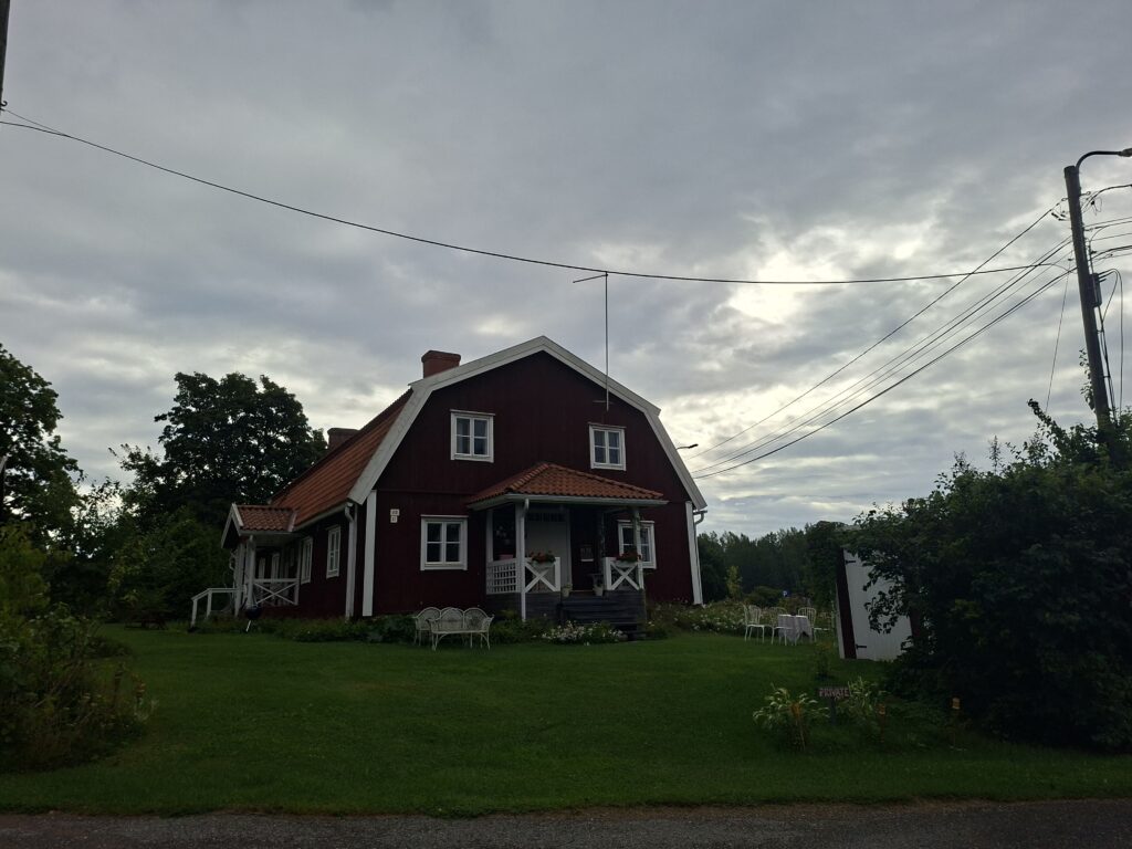 haus in Finnland . Rotes Haus in Finnland. Der Himmel ist bewölkt. Die Fensterrahmen sind Weiß . 