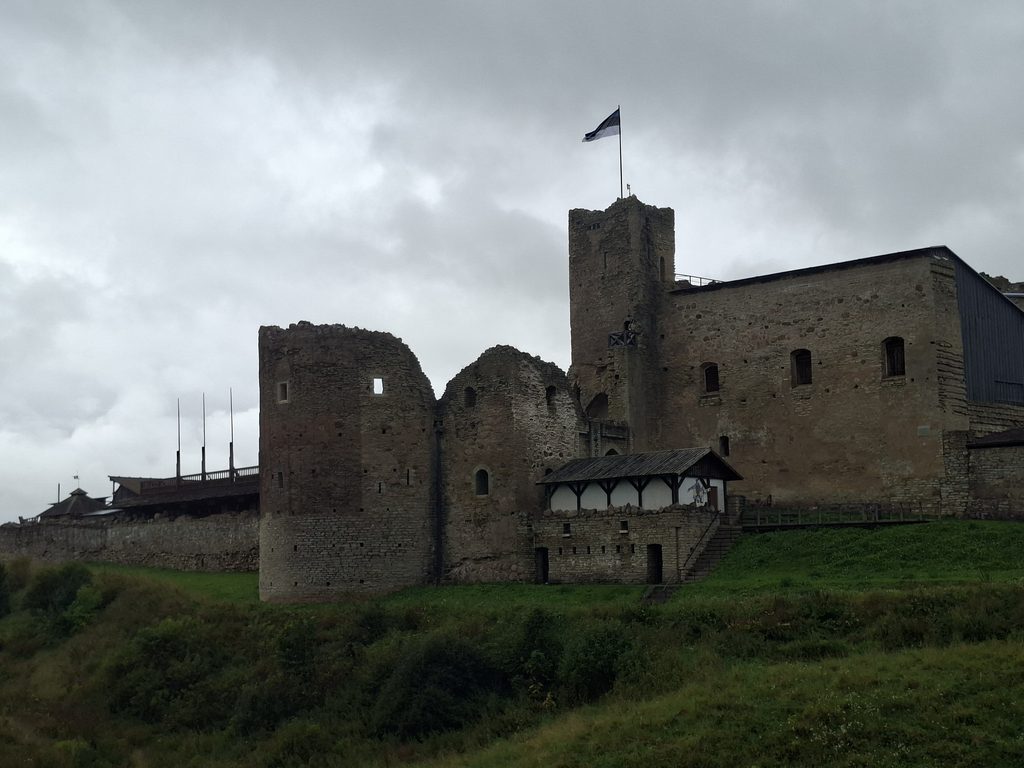 Burganlage auf unserer Reise durch Estland. Es ist Bewölkt. Auf der Burk ist eine Fahne von Estland.
